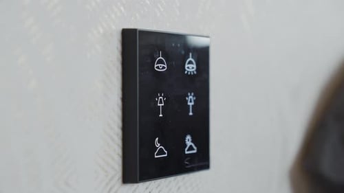 Slow motion orbiting shot of a lighting panel at the side of a bed