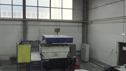 Crane Lowers Metal Plate in Manufacturing Workshop