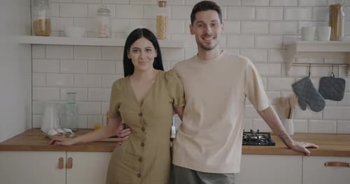 Smiling Couple Poses Together in Kitchen