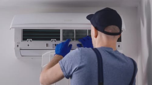 Man Installs Air Conditioner Filter Indoors
