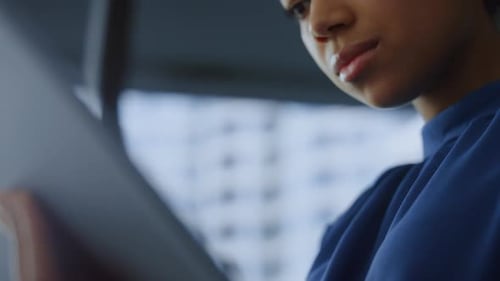 African american businesswoman thoughtfully works on digital tablet computer in office