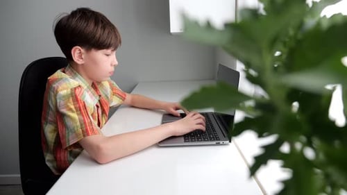 Jeune étudiant se concentrant sur la saisie rapide d'un ordinateur portable