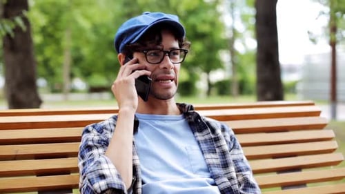 Man Talking on Phone While Sitting on Bench