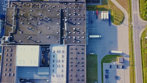 Aerial shot of industrial warehouse. Loading hub and many trucks with cargo trailers. Aerial view of