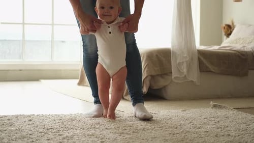 Baby Learns to Walk with Parental Assistance
