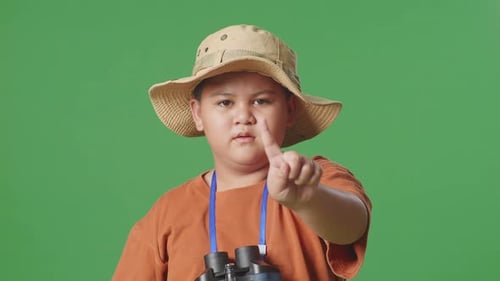 Asian Tourist Boy Researcher Using Magnifying Glass And Showing No Gesture