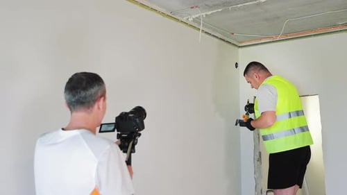 Man Paints Corner Wall While Being Filmed