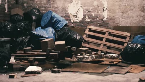 Cluttered Waste Area with Blue Bags and Wooden Pallets in an Abandoned Space