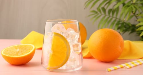 Refreshing Orange Juice Being Poured into Glass with Ice