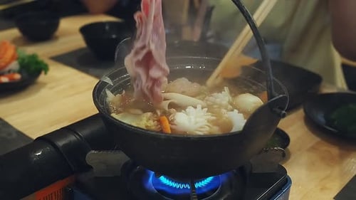 Familia cenando Shabu Shabu en un restaurante japonés. Comida de shabu-shabu
con la familia.