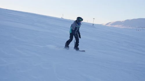 Junger Snowboarder navigiert auf der verschneiten Piste