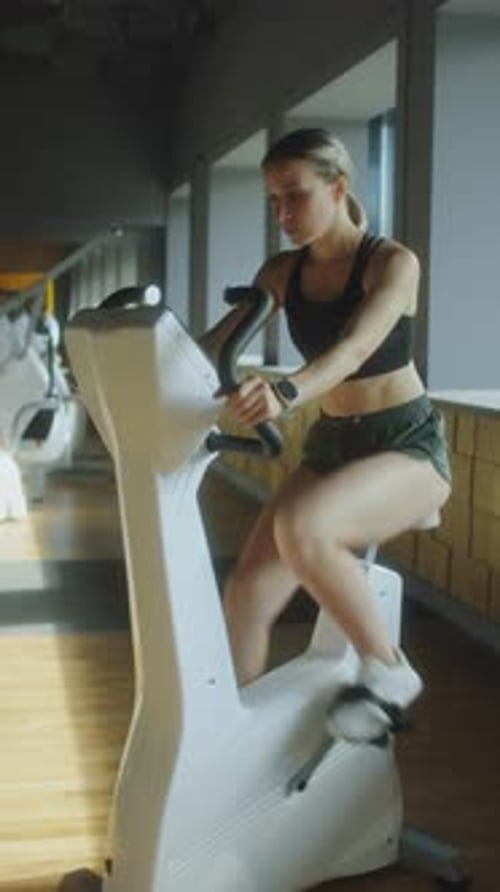 Sporty Woman Cycling in Gym