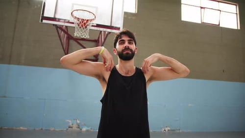 Man Warming Up Shoulders in Basketball Gym