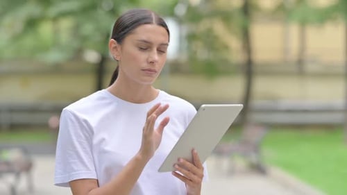 Woman Uses Tablet in Urban Park Setting