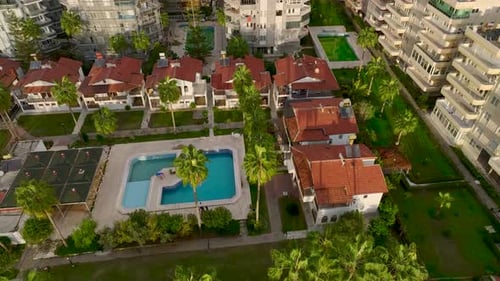 Luftbild Ein luxuriöser Pool, umgeben von grünen Palmen, befindet sich im Herzen eines Vintage-Villenkomplexes