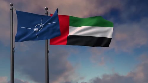 NATO and UAE Flags Waving Against Cloudy Sky
