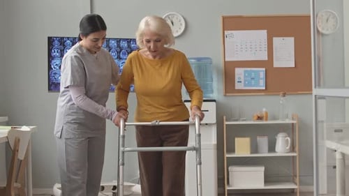 Nurse Helping Senior Woman to Walk with Walkers