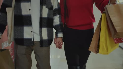 Young Couple Exploring City Streets Happily Couple Walking Together with Shopping Bags Enjoying City