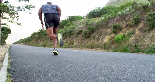 Athletic Man Running on a Road in Nature