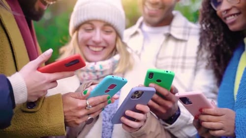 Group of Young Teenagers Friends Using Cell Phones and Walking in the City Addicted to Technology