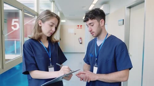 Medical Professionals Discussing Patient Information in Hospital Corridor