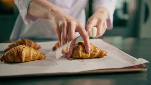 Baker Cuts Open a Delicious Croissant for Display