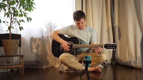Man Plays Acoustic Guitar at Home