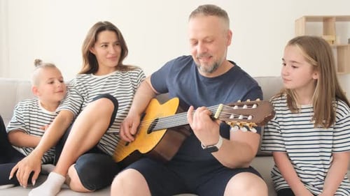Happy Family Sings Together as Father Plays Guitar
