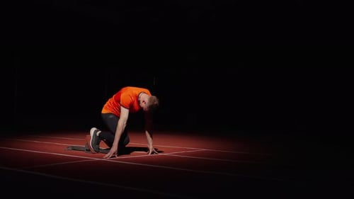 Sprinter Preparing To Start Athletic Man Standing On Starting Blocks In Sprint Lane Slow Motion