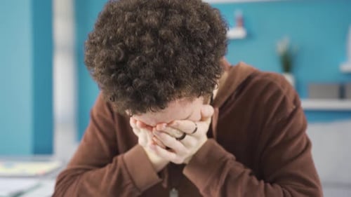Frustrated sad young man looking at laptop with despair and anger.