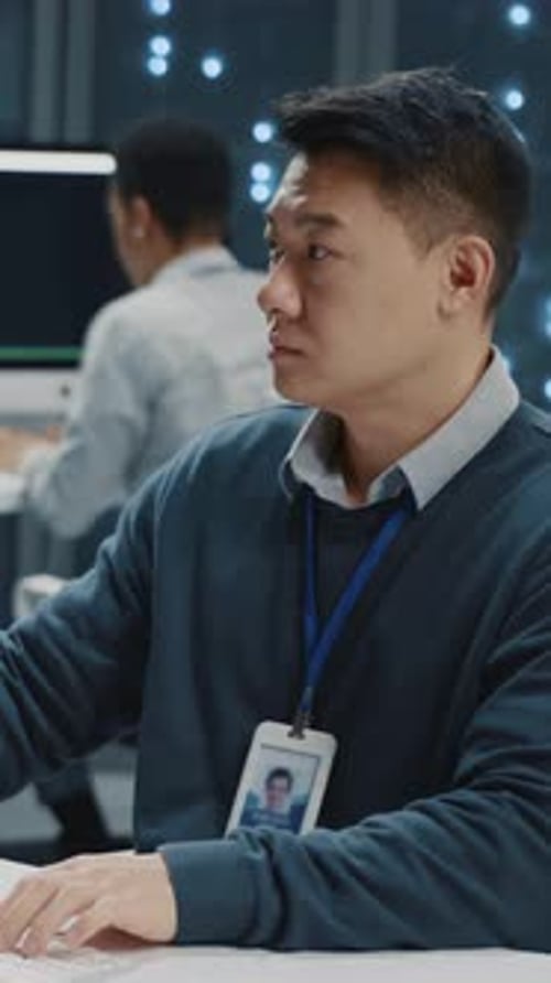 Focused Man Typing on Computer in Office Setting