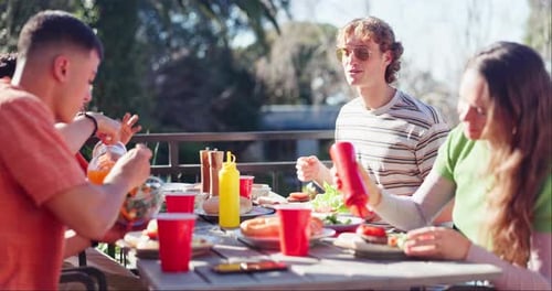 Young Adults Eating Together at an Outdoor Meal