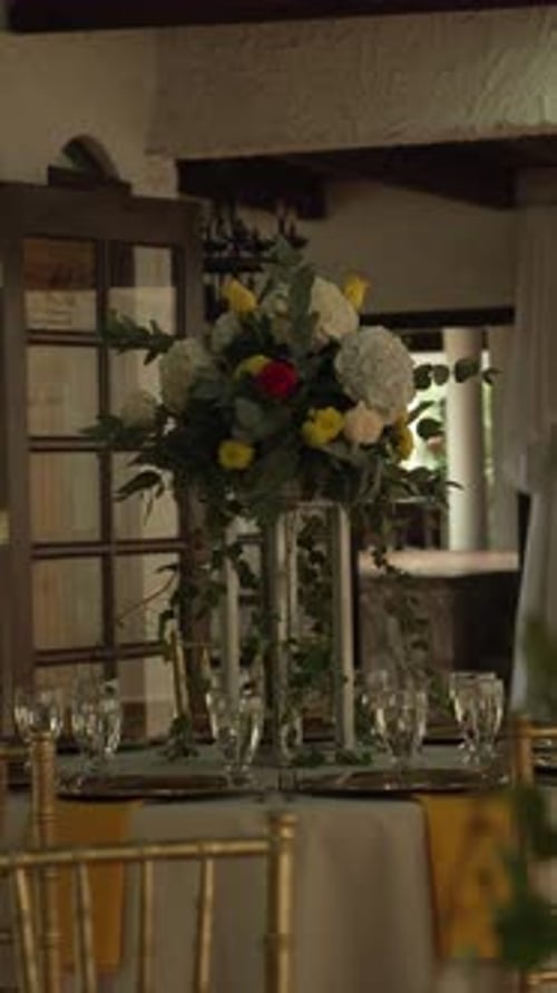 Hall with tables decorated for wedding reception with fresh flowers. Banquet table. Vertical.