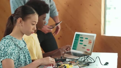 Der Lehrer steht, während er das Programmieren und die Roboterkonstruktion erklärt. Erbauung