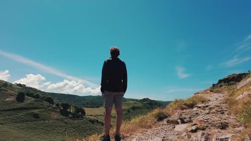 Happy Unrecognizable Man Raises His Hands Up in Mountains Conquering Peak and Serenity in World