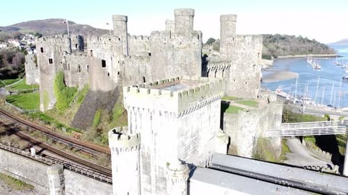 Medieval Conwy castle Welsh market town ruins aerial view historical harbour dolly left