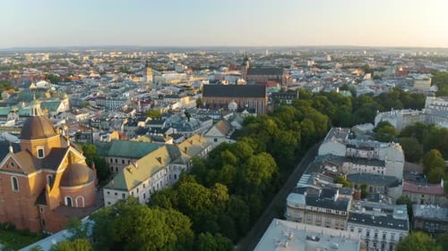 Drone Descends with Krakow Old Town Square in Background at Sunrise