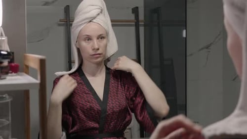 Woman in Bathrobe with Towel on Head in Bathroom Mirror