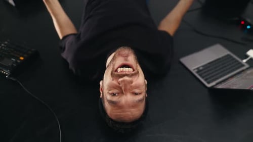 Processus créatif Un artiste masculin s'incline en faisant des gestes et en chantant dans un microphone pendant l'enregistrement de musique