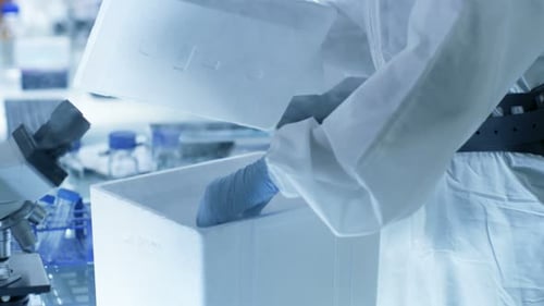 Medical Virology Research Scientist Works in a Hazmat Suit with Mask, Inspects Test Tube with Isola