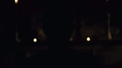 Silhouette Standing in Dark Room with Dim Lighting