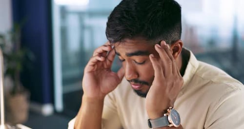 Man Massages Head in Office Close Up