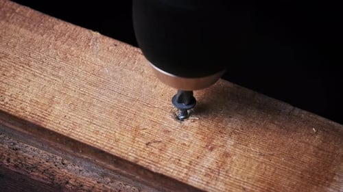 Unscrew Screw From a Wooden Board with a Screwdriver ClosePp