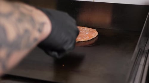 A Closeup of a Chicken Burger Patty is Fried in the Kitchen of a Restaurant