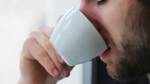 Man Drinking Coffee from White Cup, Close Up