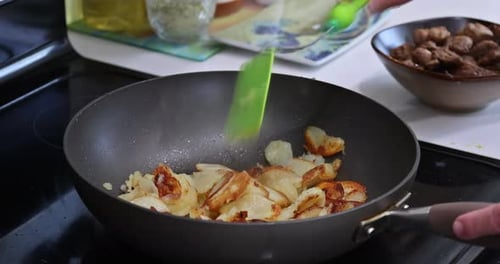 Traditional Cooking Technique Involves Roasted Potatoes and Meat in a Frying Pan on Vegetable Oil