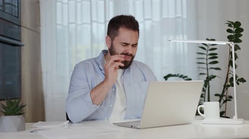 Stressed Man Working At Home On Laptop