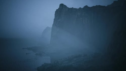 Atmospheric Fog and Light Rays on Dark Cliffs