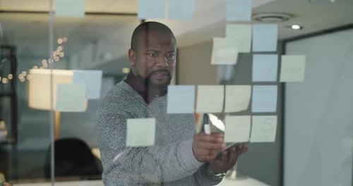 Man Planning Strategy with Sticky Notes in Office