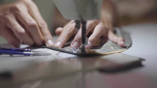 Close Up of hands sewing dress on the sewing machine
